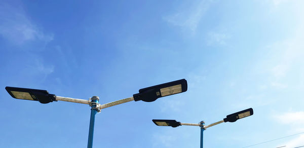 Low angle view of street light against blue sky