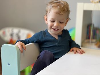 Portrait of cute baby boy sitting on table