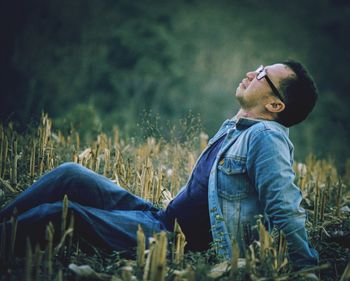 Side view of man sitting on land