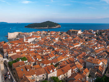 High angle view of houses by sea against sky