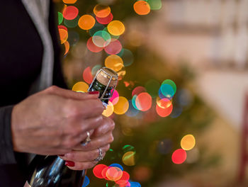 Close-up of hand holding illuminated christmas tree at night