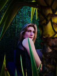 Woman looking away by plants