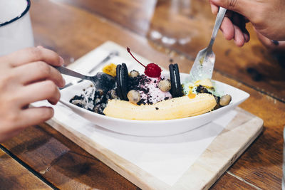 Midsection of person with ice cream on table