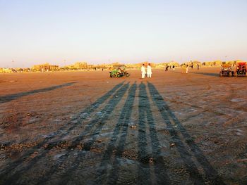 People walking on road in city against clear sky