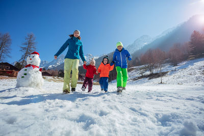 People skiing on snow covered landscape