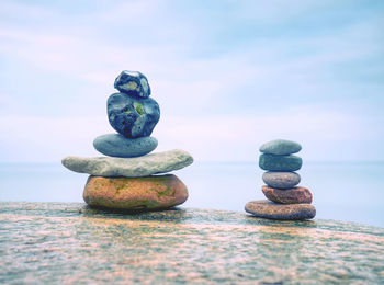 Stack of stones on the sea beach. rounded pebbles stack in evening with smooth ocean background. 