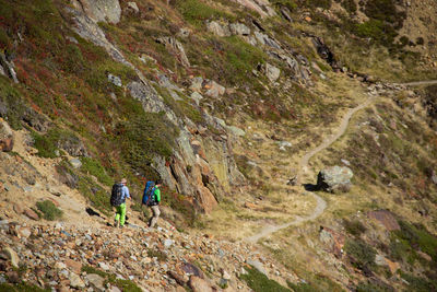 Rear view of people walking on mountain