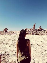 Rear view of woman standing in desert