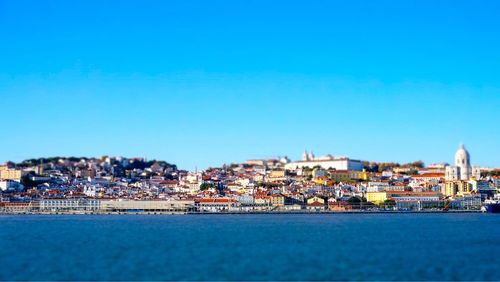 Houses in town against clear blue sky