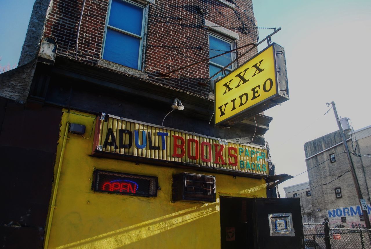 LOW ANGLE VIEW OF INFORMATION SIGN AGAINST BUILDINGS