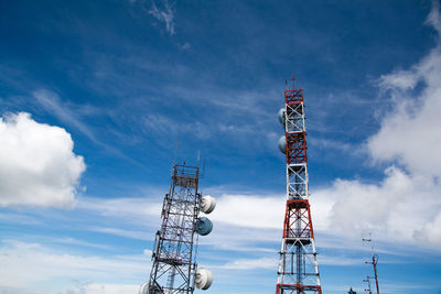 Low angle view of repeater towers against sky