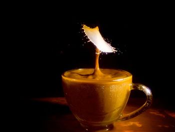 Close-up of lit candle against black background