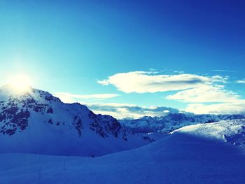 Scenic view of snow mountains against blue sky