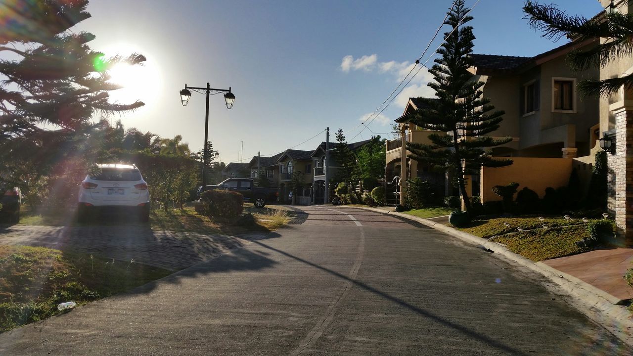 building exterior, architecture, built structure, the way forward, street, sky, diminishing perspective, tree, city, residential building, residential structure, vanishing point, house, road, street light, transportation, building, sunlight, empty, outdoors