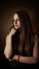 Portrait of a beautiful young woman over black background