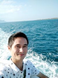 Portrait of happy boy in sea against sky