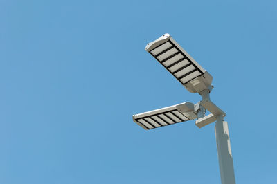 Low angle view of windmill against clear blue sky