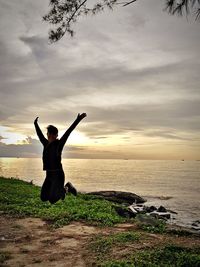 Full length of man at beach against sky during sunset