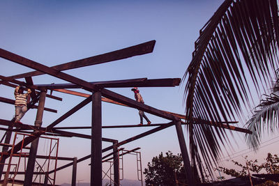 Low angle view of man working at construction site against sky