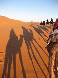 Shadow of people riding on desert