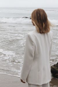 Portrait of a young woman standing by the ocean