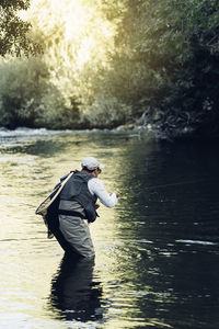 Man fishing in lake at forest