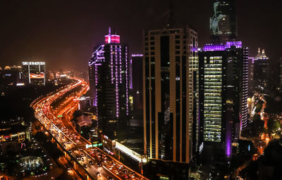 Illuminated cityscape against sky at night