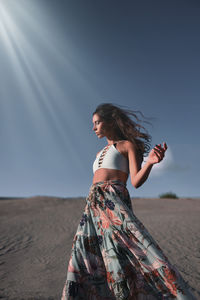 Woman standing on land against sky