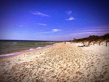 Scenic view of beach against blue sky