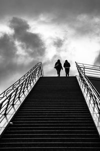 Low angle view of people on staircase against sky