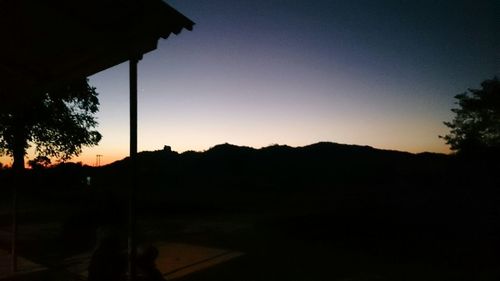 Silhouette landscape against clear sky during sunset