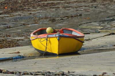 Yellow boat moored at beach