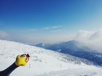 Yellow toy car on snow covered mountain against sky