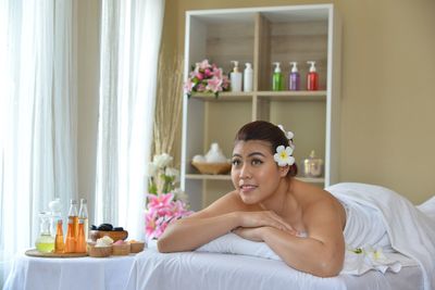 Portrait of young woman relaxing on bed at home
