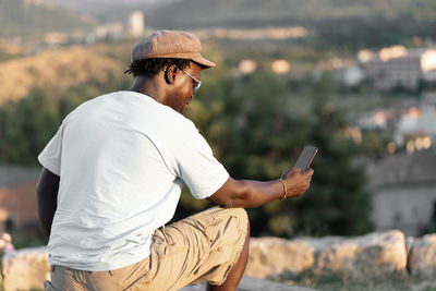 African american black skinned man with mobile phone and curly hair