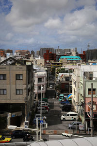 View of city street against cloudy sky