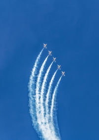 Low angle view of vapor trail against blue sky