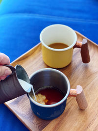 Cropped hand of woman holding coffee on table