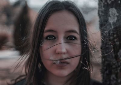 Close-up portrait of young woman exhaling smoke