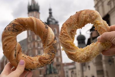 Tourist woman eating bagel obwarzanek traditional polish cuisine snack waling on market square st