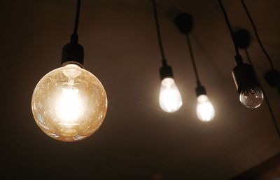 Low angle view of illuminated light bulb at night