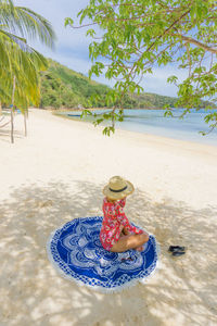 Man wearing hat on beach against sky