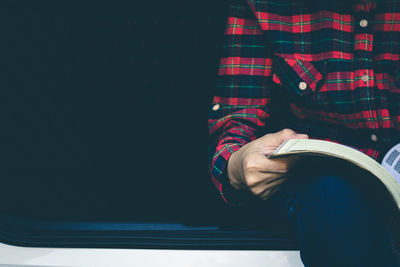 Midsection of man reading book