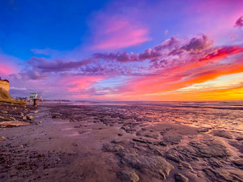 Scenic view of beach against sky during sunset