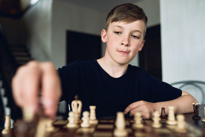 Full length portrait of boy playing with man in background