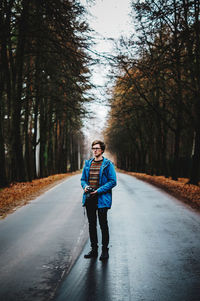 Full length of man walking on road in forest