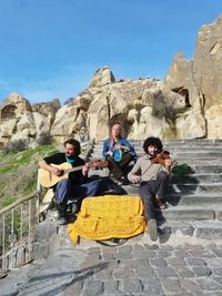 Musicians practicing on steps against clear blue sky