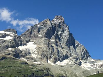 Scenic view of snowcapped mountains against blue sky