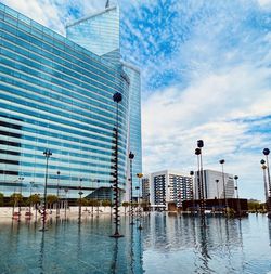 Reflection of buildings in swimming pool against sky