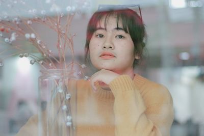 Portrait of woman looking through glass window